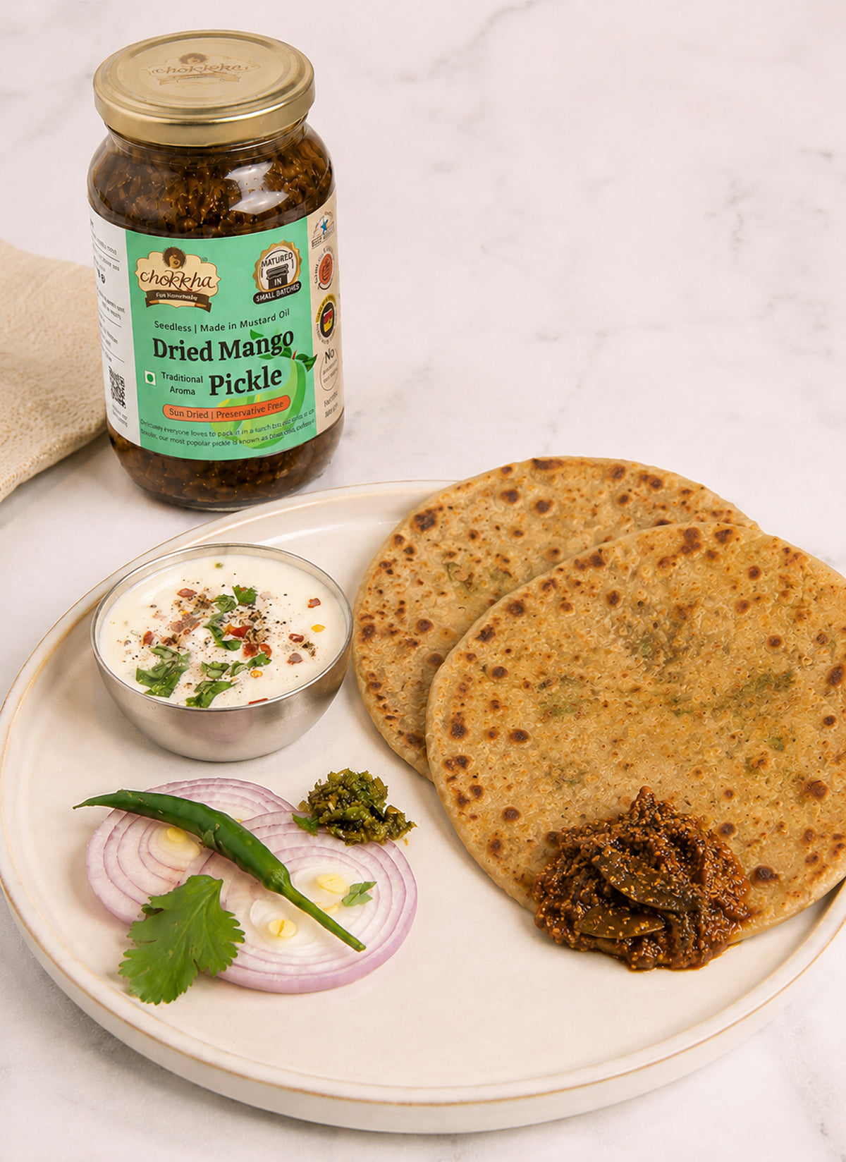Dried Mango Pickle served with parathas, curd and sliced onion